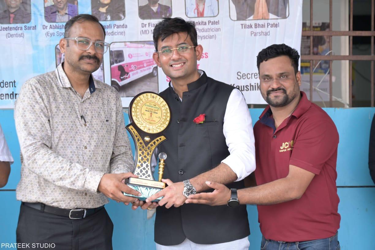 Dr. Ravi Jaiswal receiving a health camp appreciation trophy